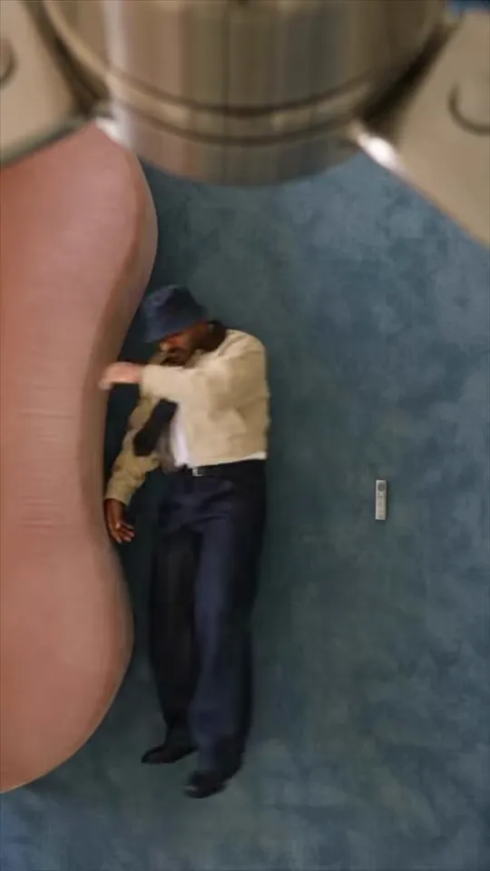 Overhead view of a man in a beige jacket, tie and bucket hat lying on a blue carpet under a chrome ceiling fan