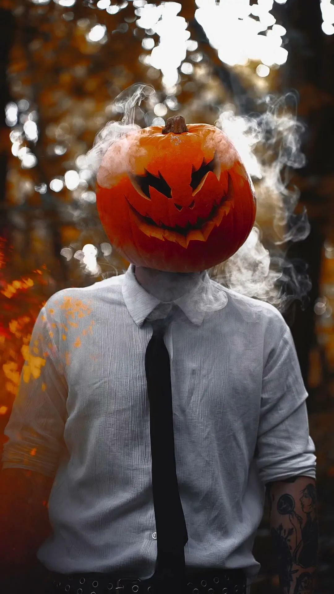A glowing carved pumpkin head placed in a cold blue night scene with thin low mist and deep shadows.