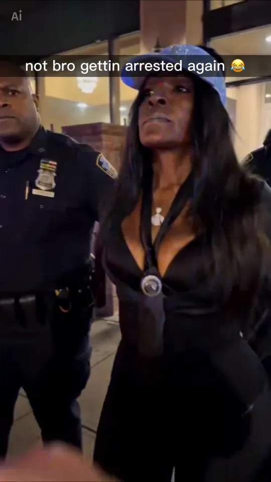 Close-up of the woman lifting her chin with a cold, calm face while the officer walks right behind her