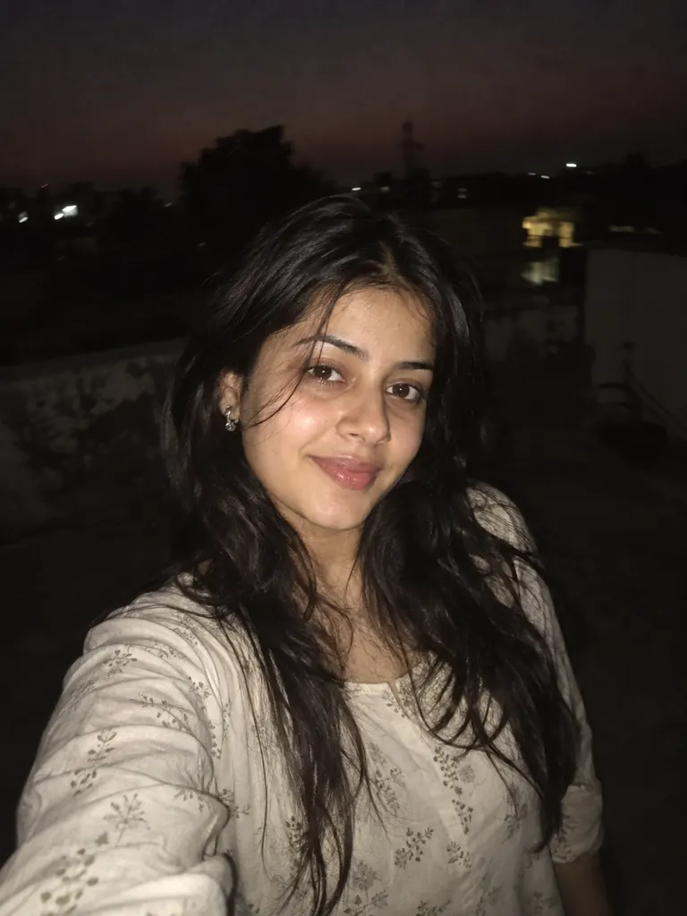 A candid lofi night selfie of you with warm film tones, lit by a direct phone flash.